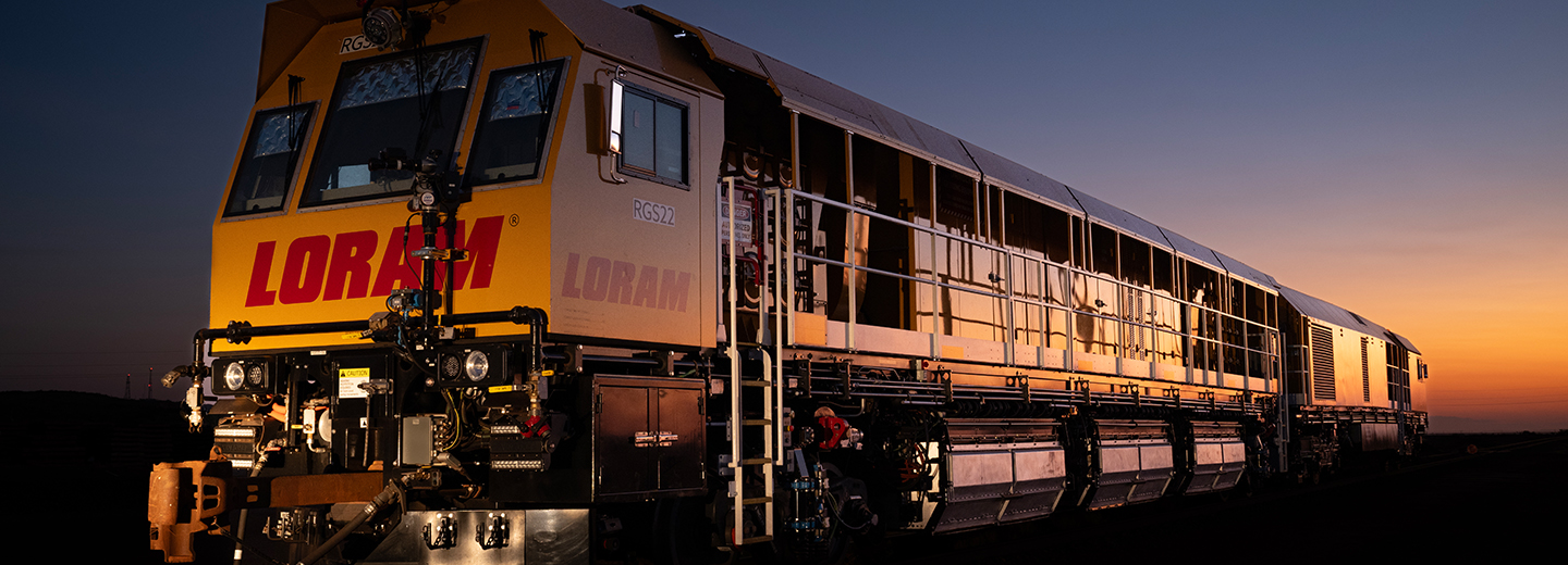 A yellow train in front of a sunset.